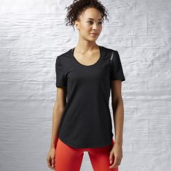 KOSZULKA - KR.REKAW BLACK/BLACK WOR SW TEE. Czarne bluzki damskie marki Reebok, z elastanu. Za 49,99 zł.