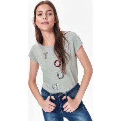 BAWEŁNIANY T-SHIRT DAMSKI Z APLIKACJĄ. Szare bluzki damskie Top Secret, z aplikacjami, z bawełny, z okrągłym kołnierzem. W wyprzedaży za 19,99 zł.