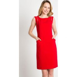 Czerwona sukienka z zamkami na ramionach QUIOSQUE. Czerwone sukienki dzianinowe QUIOSQUE, na spotkanie biznesowe, na lato, s, bez rękawów. W wyprzedaży za 79,99 zł.