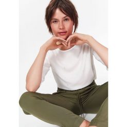 BLUZKA Z RĘKAWEM 3/4 W DELIKATNY NADRUK. Białe bluzki damskie marki Top Secret, z nadrukiem, z tkaniny, z okrągłym kołnierzem, bez rękawów. W wyprzedaży za 29,99 zł.