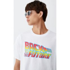 Koszulka z logo filmu Powrót do przyszłości. Białe koszulki męskie Pull&Bear, m, bez wzorów, bez kołnierzyka, z krótkim rękawem, krótkie. Za 69,90 zł.