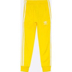 Adidas Originals - Spodnie dziecięce 128-164 cm. Żółte spodnie chłopięce marki adidas Originals, z materiału. W wyprzedaży za 129,90 zł.