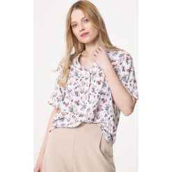 Biała Bluzka Run Chase. Białe bluzki damskie Born2be, na imprezę, xl, z aplikacjami, bez kołnierzyka, z krótkim rękawem. Za 79,99 zł.