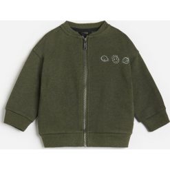 Bluza dresowa z nadrukiem -. Bluzy męskie Reserved, z nadrukiem, z dresówki, bez kołnierzyka, bez rękawów, bez kaptura. Za 49,99 zł.