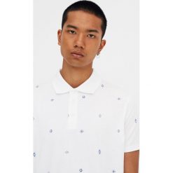 Biała koszulka polo z drobnym nadrukiem. Białe koszulki męskie Pull&Bear, m, z nadrukiem, z krótkim rękawem. Za 59,90 zł.