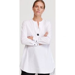 Tunika z dekoltem V - Kremowy. Białe tuniki damskie Reserved, bez wzorów, bez kołnierzyka, bez rękawów. Za 119,99 zł.
