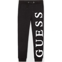 Guess Jeans - Spodnie dziecięce 118-175 cm. Szare spodnie chłopięce Guess Jeans, z nadrukiem, z bawełny, casualowe. Za 129,90 zł.