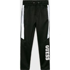 Guess Jeans - Spodnie dziecięce 118-175 cm. Czarne spodnie chłopięce Guess Jeans, z aplikacjami, z bawełny, casualowe. W wyprzedaży za 129,90 zł.