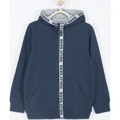 Coccodrillo - Bluza dziecięca 104-158 cm. Niebieskie bluzy chłopięce COCCODRILLO, z aplikacjami, z dzianiny, bez rękawów, z kapturem. W wyprzedaży za 34,90 zł.