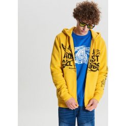 Zapinana bluza Baltic Games - Żółty. Żółte bluzy męskie Cropp, s, bez wzorów, bez kołnierzyka, bez rękawów, bez kaptura. Za 139,99 zł.