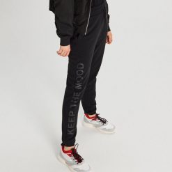 Spodnie dresowe z napisem - Czarny. Czarne spodnie damskie Cropp, s, z dresówki. Za 89,99 zł.