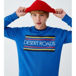Bluza z napisem „Desert roads”. Niebieskie bluzy męskie Pull&Bear, m, z napisami, bez kołnierzyka, bez rękawów, bez kaptura. Za 62,90 zł.