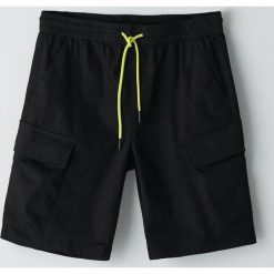 Szorty jogger z kieszeniami cargo - Czarny. Czarne spodenki i szorty męskie Cropp, bez wzorów. W wyprzedaży za 62,99 zł.