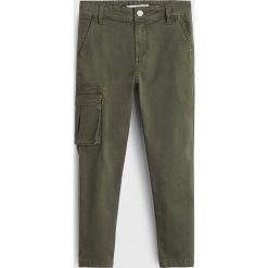 Mango Kids - Spodnie dziecięce Liam 110-164 cm. Żółte spodnie chłopięce Mango Kids, bez wzorów, z elastanu. W wyprzedaży za 59,90 zł.