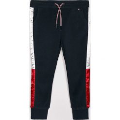 Tommy Hilfiger - Spodnie dziecięce 104-176 cm. Niebieskie spodnie dziewczęce TOMMY HILFIGER, bez wzorów, z elastanu, casualowe. W wyprzedaży za 219,90 zł.