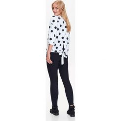 Nierozpinana bluza damska w kropki z wiązaniem w pasie. Białe bluzy damskie na zimę, w grochy, z dzianiny. W wyprzedaży za 39,99 zł.