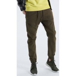 Dresowe joggery z kieszenią na zamek - Khaki. Brązowe spodnie męskie marki Cropp, m, bez wzorów, z dresówki. Za 129,99 zł.