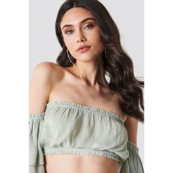 Linn Ahlborg x NA-KD Top z krepy z odkrytymi ramionami - Green. Zielone topy damskie marki Linn Ahlborg x NA-KD, bez wzorów, z falbankami. W wyprzedaży za 50,47 zł.