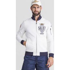 BLUZA Aeronautica Militare. Białe bluzy męskie Aeronautica Militare, s, z haftami, z elastanu, bez kołnierzyka, bez rękawów, bez kaptura. Za 789,00 zł.
