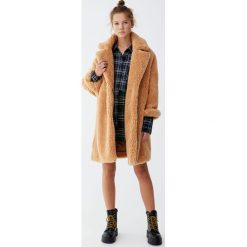 Długi płaszcz ze sztucznego futerka w kolorze ochry. Pomarańczowe płaszcze damskie marki Pull&Bear, bez wzorów, długie. Za 299,00 zł.