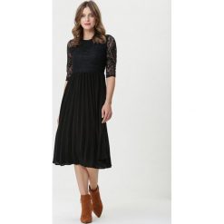 Czarna Sukienka Rambouillet. Czarne sukienki damskie Born2be, s, bez wzorów, z koronki, z okrągłym kołnierzem, bez rękawów, midi, plisowane. Za 119,99 zł.