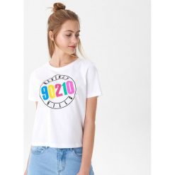 T-shirt z nadrukiem Beverly Hills 90210 - Biały. Białe t-shirty damskie House, xl, z nadrukiem, bez kołnierzyka. W wyprzedaży za 19,99 zł.