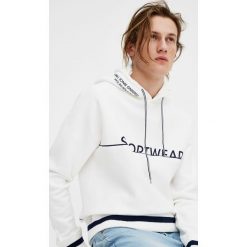 Bluza z kapturem i paskami. Białe bluzy damskie z kapturem marki Pull & Bear, w paski. Za 39,90 zł.