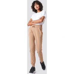 NA-KD Basic Spodnie dresowe basic - Beige. Brązowe spodnie damskie marki NA-KD Basic, z bawełny, z podwyższonym stanem. Za 100,95 zł.