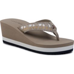Japonki TOMMY HILFIGER - Th Webbing Wedge Beach Sandal FW0FW04628 Stone AEP. Brązowe klapki damskie TOMMY HILFIGER, bez wzorów, z tworzywa sztucznego, bez obcasa, na obcasie. W wyprzedaży za 189,00 zł.