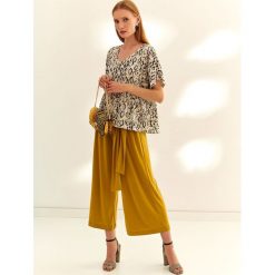 Bluzka krótki rękaw o luźnym kroju. Brązowe bluzki damskie Top Secret, bez wzorów, z tkaniny, eleganckie, z dekoltem w serek, z krótkim rękawem. W wyprzedaży za 39,99 zł.