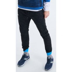 Dresowe joggery z nadrukiem all over - Czarny. Czarne spodnie męskie marki Cropp, s, z nadrukiem, z dresówki. Za 119,99 zł.