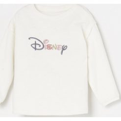 Bluzka z haftowanym napisem Disney - Kremowy. Białe bluzki damskie Reserved, z haftami, bez kołnierzyka, bez rękawów. Za 39,99 zł.