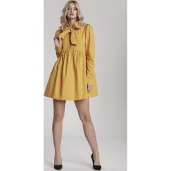 Żółta Sukienka Thessaciane. Żółte sukienki damskie Renee, na imprezę, s, bez wzorów, eleganckie, z klasycznym kołnierzykiem, z długim rękawem, długie, mini, rozkloszowane. Za 129,99 zł.