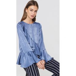 Rut&Circle Top z falbaną Hanna - Blue. Niebieskie topy damskie marki Rut&Circle, bez wzorów, z poliesteru, bez kołnierzyka. W wyprzedaży za 64,78 zł.