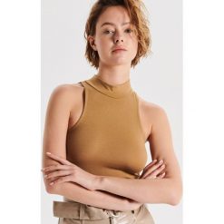 Prążkowany top z dekoltem halter - Brązowy. Pomarańczowe topy damskie Cropp, s, bez wzorów, prążkowane, bez kołnierzyka. Za 24,99 zł.