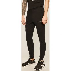 New Balance - Spodnie. Czarne spodnie męskie New Balance, s, z nadrukiem, z bawełny. W wyprzedaży za 249,90 zł.