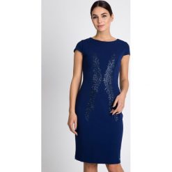 Granatowa sukienka z błyszczącym wzorem QUIOSQUE. Czarne sukienki mini marki QUIOSQUE, na imprezę, z tkaniny, eleganckie, z kopertowym dekoltem, dopasowane. W wyprzedaży za 109,99 zł.