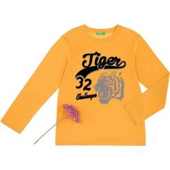 Koszulka w kolorze pomarańczowym. Pomarańczowe t-shirty chłopięce Benetton Kids, z nadrukiem, z bawełny, z długim rękawem. W wyprzedaży za 25,95 zł.