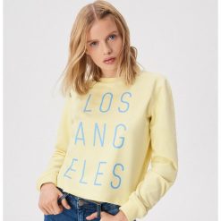 Pastelowa bluza z napisem - Żółty. Żółte bluzy damskie Sinsay, s, z napisami, bez rękawów, bez kaptura. W wyprzedaży za 14,99 zł.