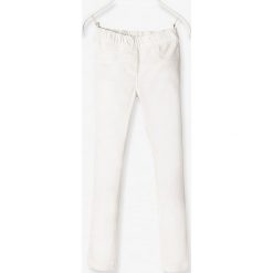 Tregginsy w kolorze w kolorze białym. Białe spodnie niemowlęce Vertbaudet Girls & Co., bez wzorów, z materiału. W wyprzedaży za 27,95 zł.
