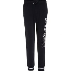 Abercrombie & Fitch VARSITY Spodnie treningowe navy. Niebieskie spodnie dresowe dziewczęce marki Abercrombie & Fitch, z bawełny. W wyprzedaży za 132,30 zł.