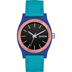 Zegarek kwarcowy "Medium Time Teller" w kolorze turkusowo-niebiesko-złotym. Niebieskie, analogowe zegarki damskie Nixon, złote. W wyprzedaży za 129,95 zł.
