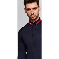 Koszula z dzianinowym kołnierzem o kroju slim. Koszule męskie Top Secret, na lato, m, bez wzorów, z jeansu, eleganckie, z kontrastowym kołnierzykiem, bez rękawów. W wyprzedaży za 49,99 zł.