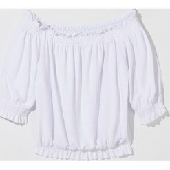Bluzka open shoulder z falbaną -. Bluzki damskie Mohito, s, bez wzorów, bez kołnierzyka, bez rękawów. W wyprzedaży za 49,99 zł.