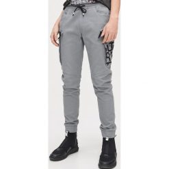 Joggery cargo z nadrukiem - Jasny szary. Szare spodnie męskie Cropp, m, z nadrukiem. Za 149,99 zł.