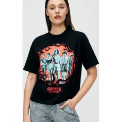 Koszulka Stranger Things - Czarny. Czarne koszulki damskie Cropp, s, bez wzorów, bez kołnierzyka, bez rękawów. Za 59,99 zł.