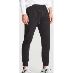 Spodnie dresowe slim fit - Czarny. Czarne spodnie męskie marki Reserved, s, bez wzorów, z dresówki. Za 129,99 zł.