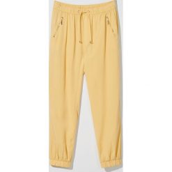 Spodnie jogger fit z lyocellu - Żółty. Żółte spodnie damskie Mohito, bez wzorów, z lyocellu. Za 99,99 zł.