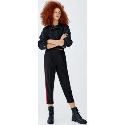 Spodnie z dzianiny dresowej z lampasem. Zielone spodnie damskie marki Pull&Bear, z dzianiny. Za 59,90 zł.