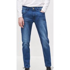 Spodnie jeansowe slim -. Spodnie męskie Reserved, bez wzorów, z jeansu. W wyprzedaży za 59,99 zł.